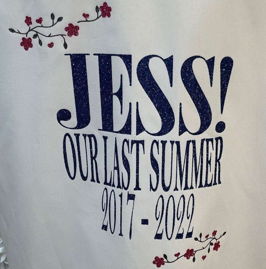 Personalised Glitter School Leavers Signing Shirt for Class of 2026 – “Our Last Summer” design inspired by the ABBA song, featuring blue glitter wording and pink glitter flowers. A fun keepsake for children to celebrate the last day of school