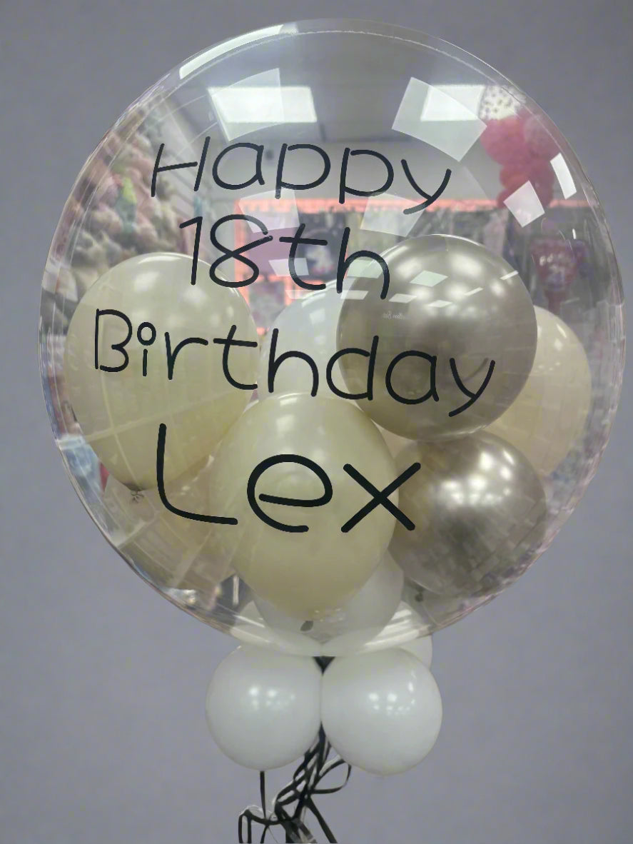 Helium inflated 24 inch personalised bubble balloon, personalised in the theme champagne gold, ivory, white mini balloons. Personalised in a black font.
