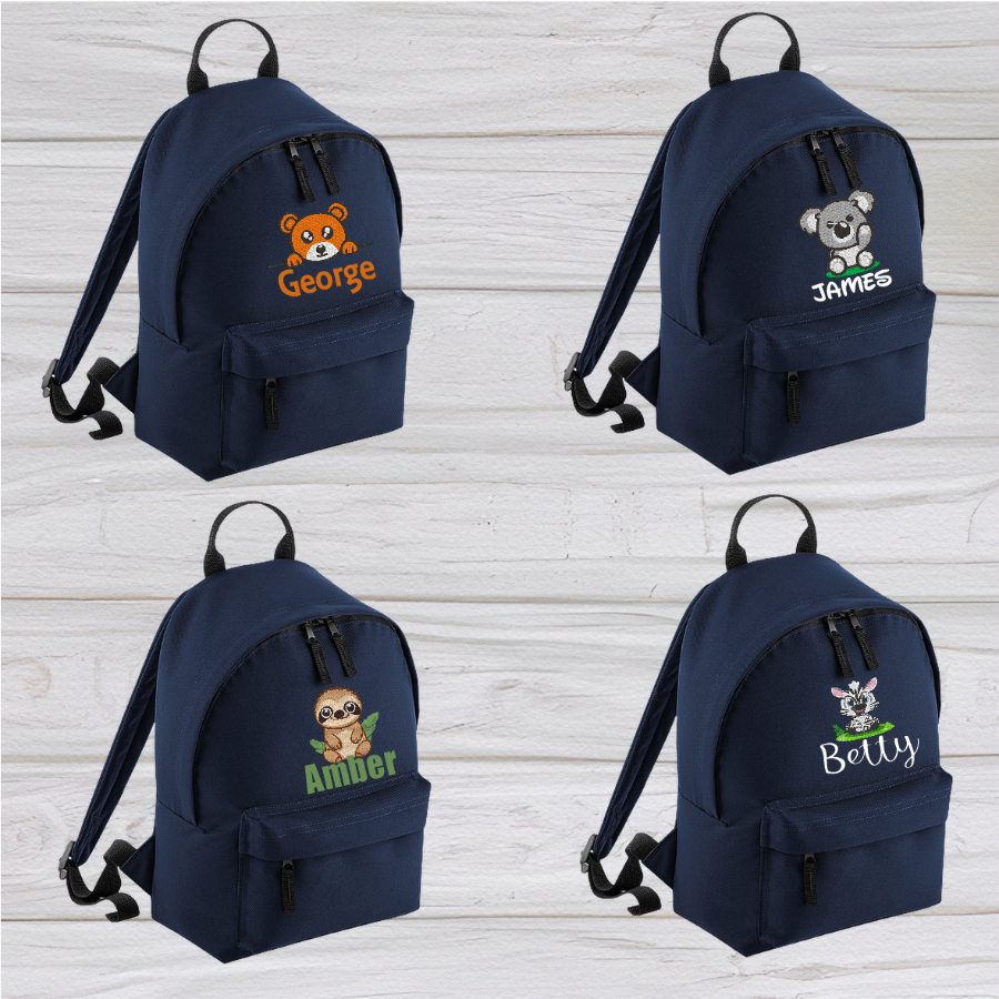 Introducing the fabulously fashionable, petite-sized Personalised Mini School Backpack! It's got it all: a nifty zippered front pocket, extra-cushy back panel and adjustable shoulder straps, plus a handy grab handle to boot!  Colour - Navy Blue Rucksack Dimensions - 24 x 33 x 17cm. Capacity 9 litres.  Choose between 4 colours - Jet Black, Jungle Camo, Navy Blue, Pretty in Pink!  Personalisation comes complimentary - no extra cost!