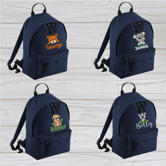 Introducing the fabulously fashionable, petite-sized Personalised Mini School Backpack! It's got it all: a nifty zippered front pocket, extra-cushy back panel and adjustable shoulder straps, plus a handy grab handle to boot!  Colour - Navy Blue Rucksack Dimensions - 24 x 33 x 17cm. Capacity 9 litres.  Choose between 4 colours - Jet Black, Jungle Camo, Navy Blue, Pretty in Pink!  Personalisation comes complimentary - no extra cost!