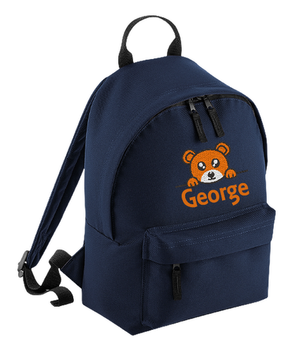 Introducing the fabulously fashionable, petite-sized Personalised Mini School Backpack! It's got it all: a nifty zippered front pocket, extra-cushy back panel and adjustable shoulder straps, plus a handy grab handle to boot!  Colour - Navy Blue Rucksack Dimensions - 24 x 33 x 17cm. Capacity 9 litres.  Choose between 4 colours - Jet Black, Jungle Camo, Navy Blue, Pretty in Pink!  Personalisation comes complimentary - no extra cost!