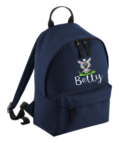 Introducing the fabulously fashionable, petite-sized Personalised Mini School Backpack! It's got it all: a nifty zippered front pocket, extra-cushy back panel and adjustable shoulder straps, plus a handy grab handle to boot!  Colour - Navy Blue Rucksack Dimensions - 24 x 33 x 17cm. Capacity 9 litres.  Choose between 4 colours - Jet Black, Jungle Camo, Navy Blue, Pretty in Pink!  Personalisation comes complimentary - no extra cost!