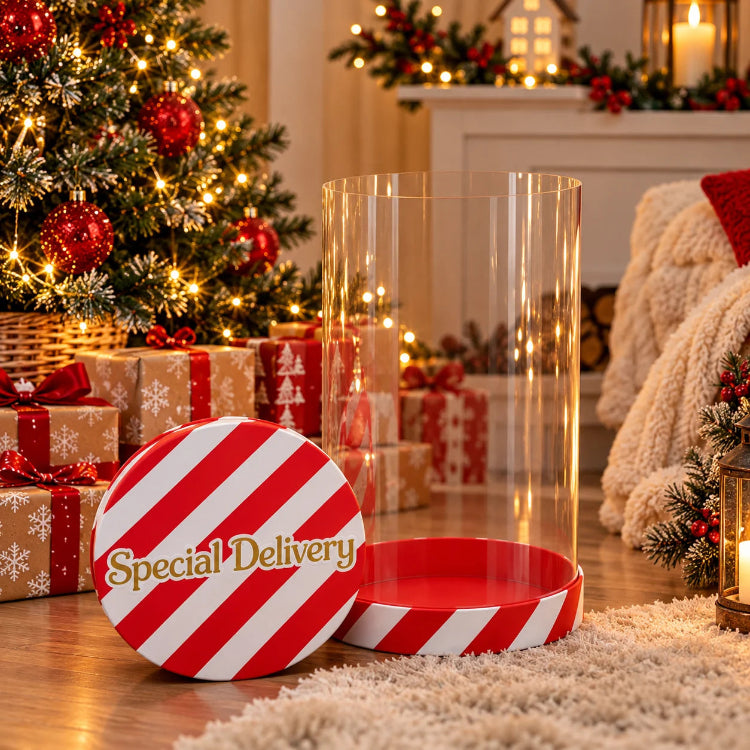 Elf Arrival Cylinder Box displayed beside a decorated Christmas tree