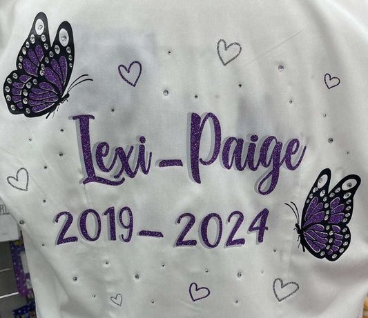 Custom Class of 2026 glitter and diamanté butterfly signing shirt with glitter hearts, personalized name and dates, optional feather trims and bows – perfect leavers shirt to celebrate the end of school year.
