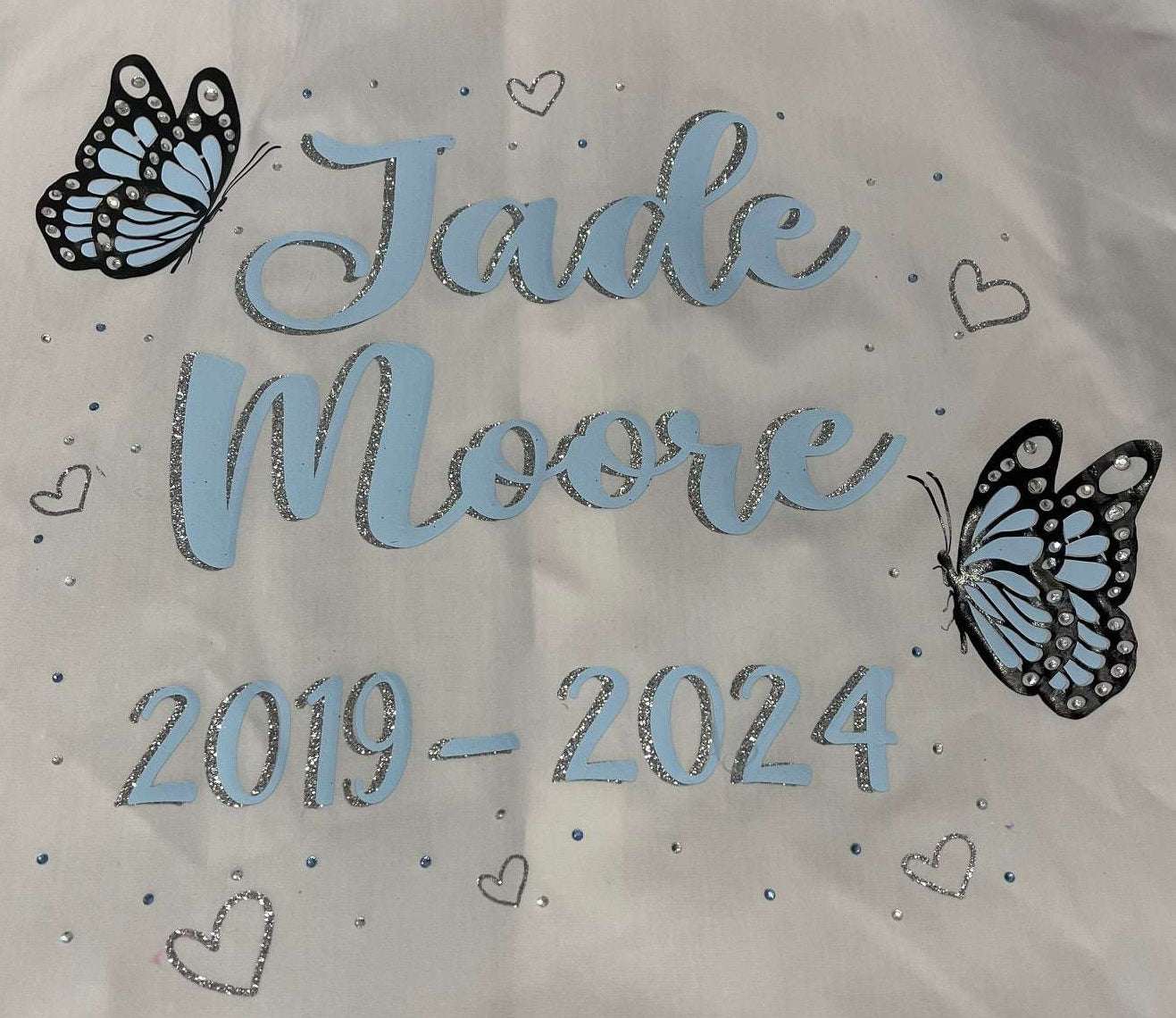Custom Class of 2026 glitter and diamanté baby blue butterfly signing shirt with glitter silver hearts, personalized name and dates.