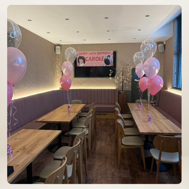 60th birthday helium balloons on tables with a personalised photo birthday banner at the Eccleston Arms, St Helens
