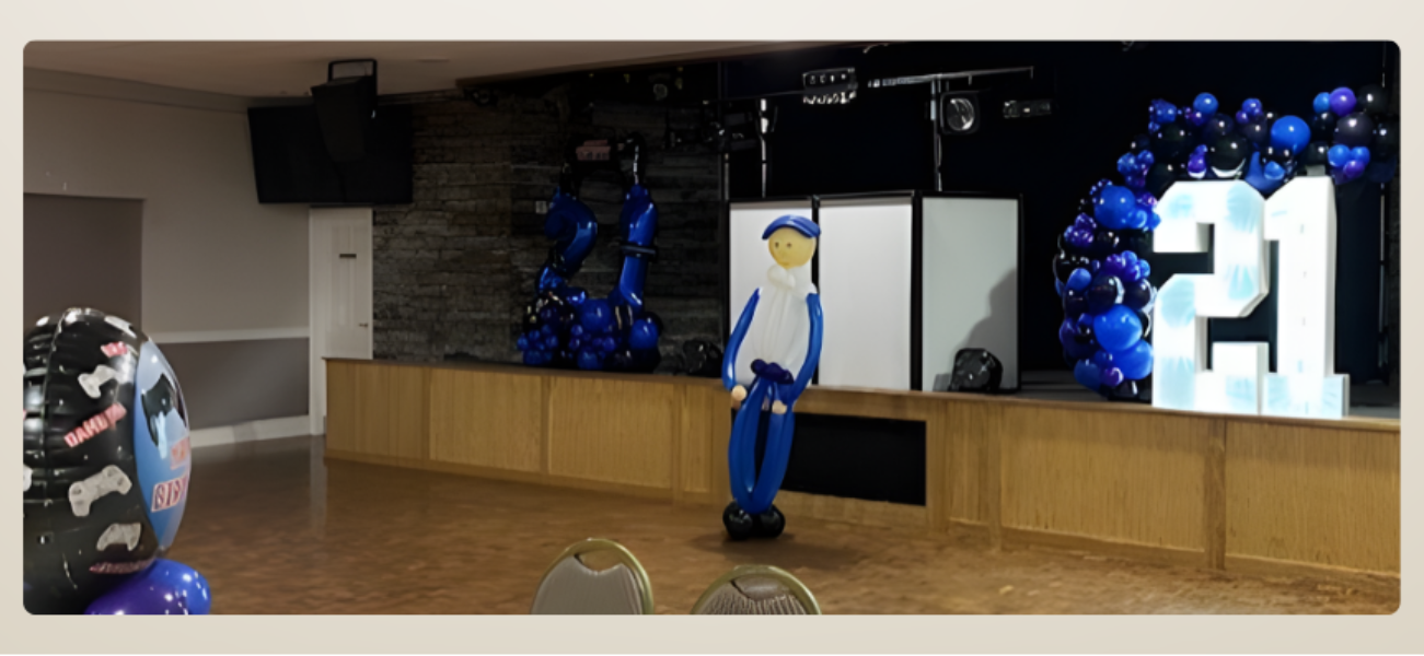 Decorative setup with blue and white figures, balloons, and a large light up number '21' and organic balloon arch at Sidac Social Club, St Helens