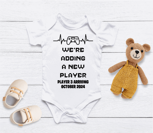 Capture your pregnancy announcement with this adorable personalised Adding A New Player baby grow! Personalised with Arrival Month; Year. Inform all your family, friends and even the world in the best way possible with a personalised short sleeved bodysuit. Share your excitement on social media platforms with the unique touch of a custom baby bodysuit. It also makes for the perfect baby shower gift.