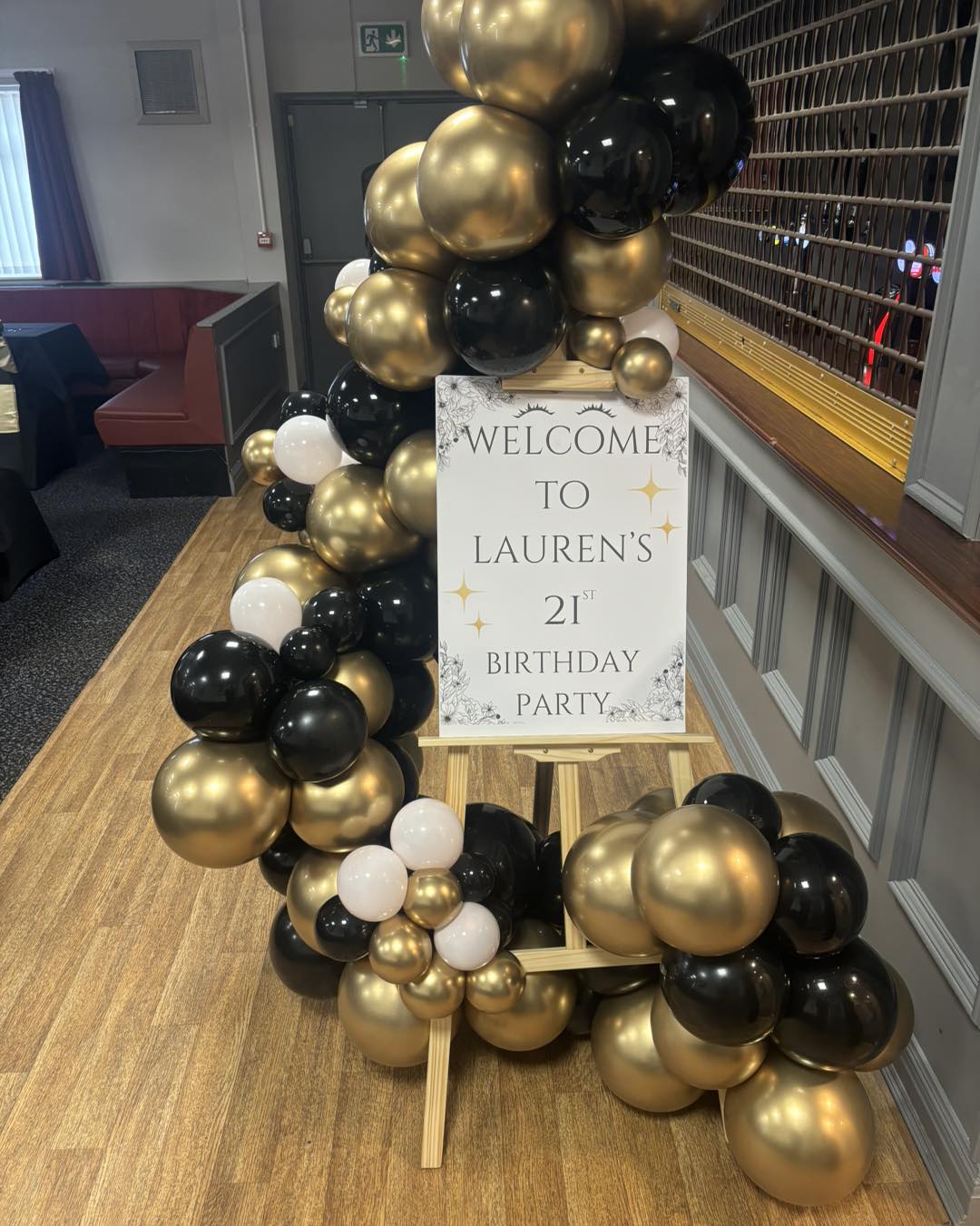 Personalised welcome sign with organic arch displayed on a wooden easel