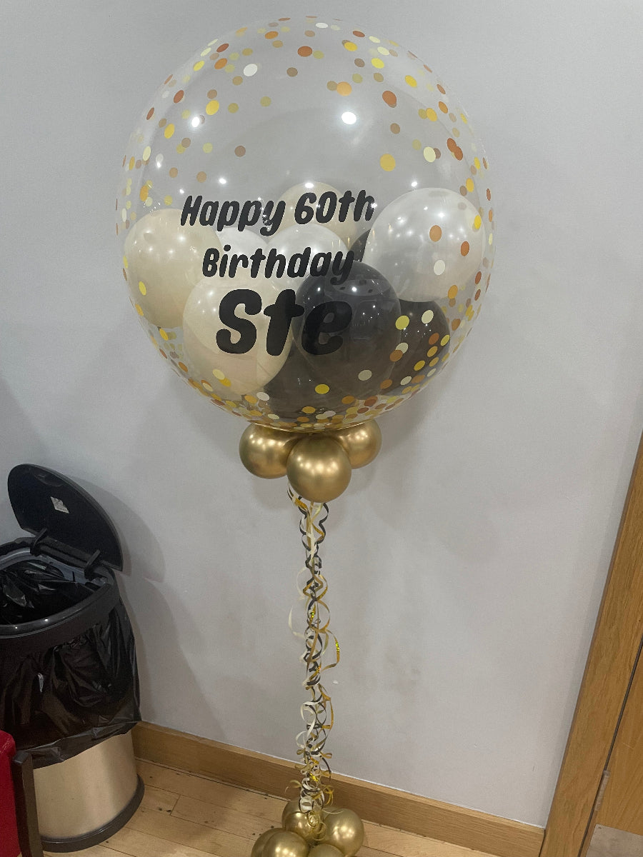 Helium inflated 24 inch personalised bubble balloon, this example shows black white sand, white mini balloons with black personalisation.